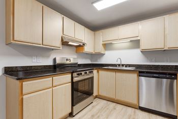 A kitchen with wooden cabinets and stainless steel appliances.